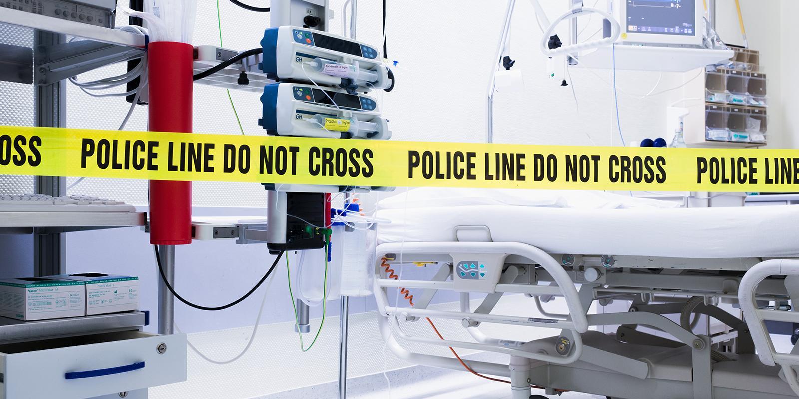 Police tape surrounding a hospital bed